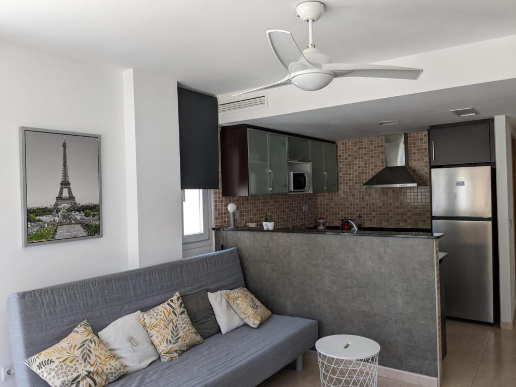 Una sala de estar con un sofá y una cocina con la Torre Eiffel. en Oliva Moon, en Oliva