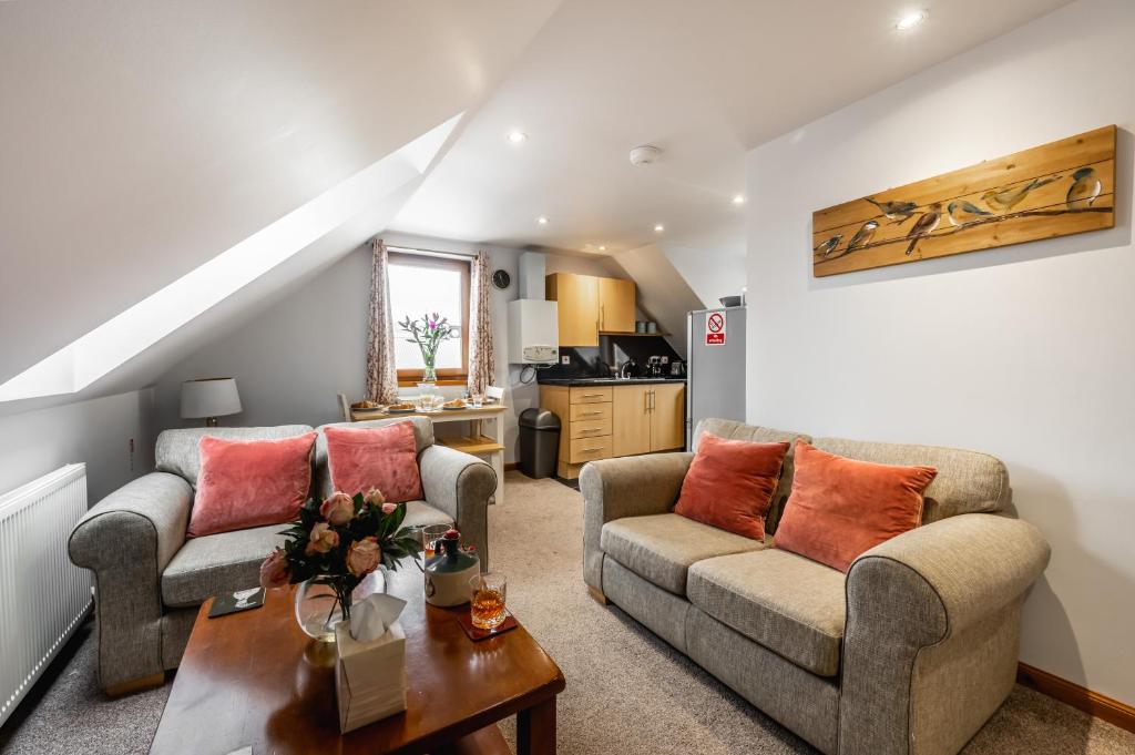 a living room with two couches and a table at Aldo's Place in Dingwall