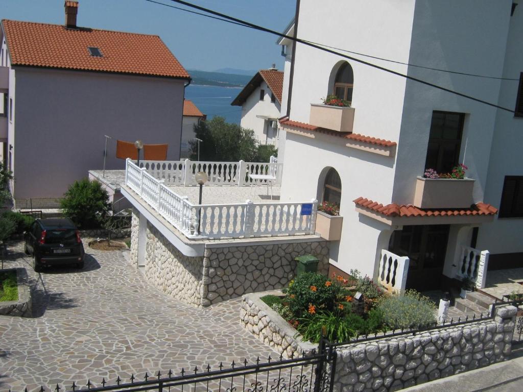 ein weißes Gebäude mit einem Balkon und einer Straße in der Unterkunft Matea in Crikvenica