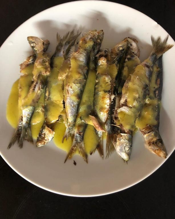 a white plate of fish with mustard on it at Gregory's Village in Platy