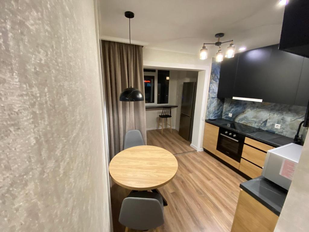 基希讷乌Sweethome Riscani的一间带木桌的小厨房和一间餐厅