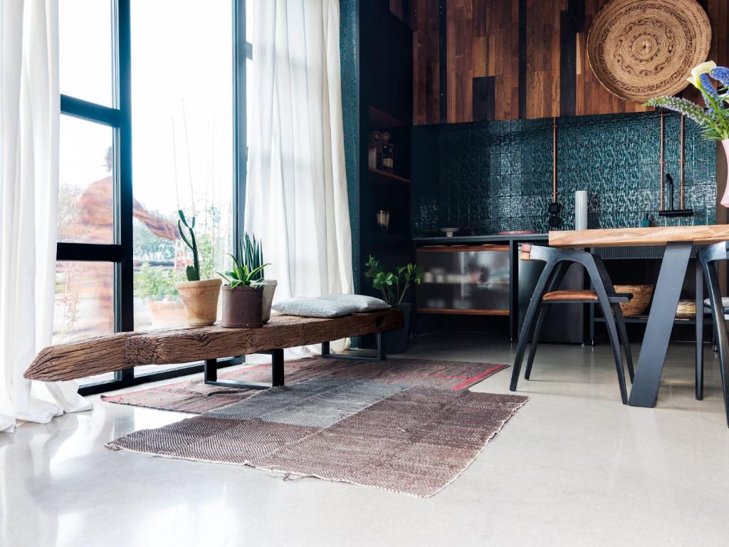 una sala de estar con un banco de madera y una mesa. en Nyu Domo b&b en Sedilo