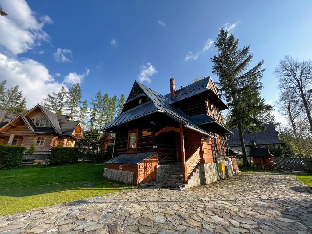 a large wooden house on a stone driveway at Willa u Adama in Zakopane