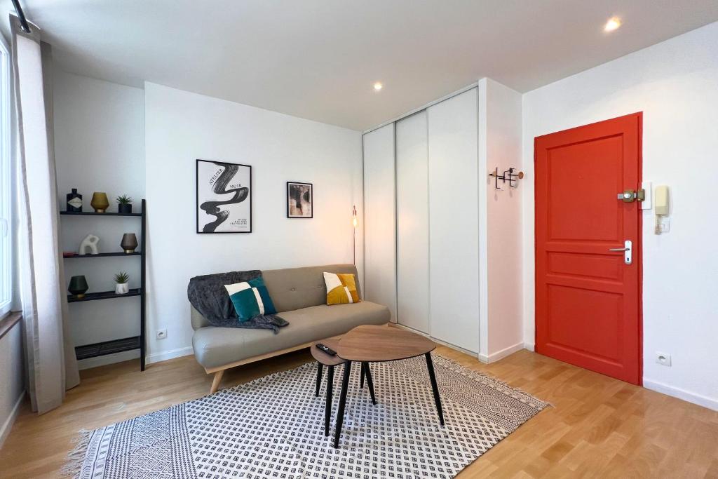 sala de estar con sofá y puerta roja en Appart 2 personnes Cherbourg Hyper centre, en Cherbourg-en-Cotentin