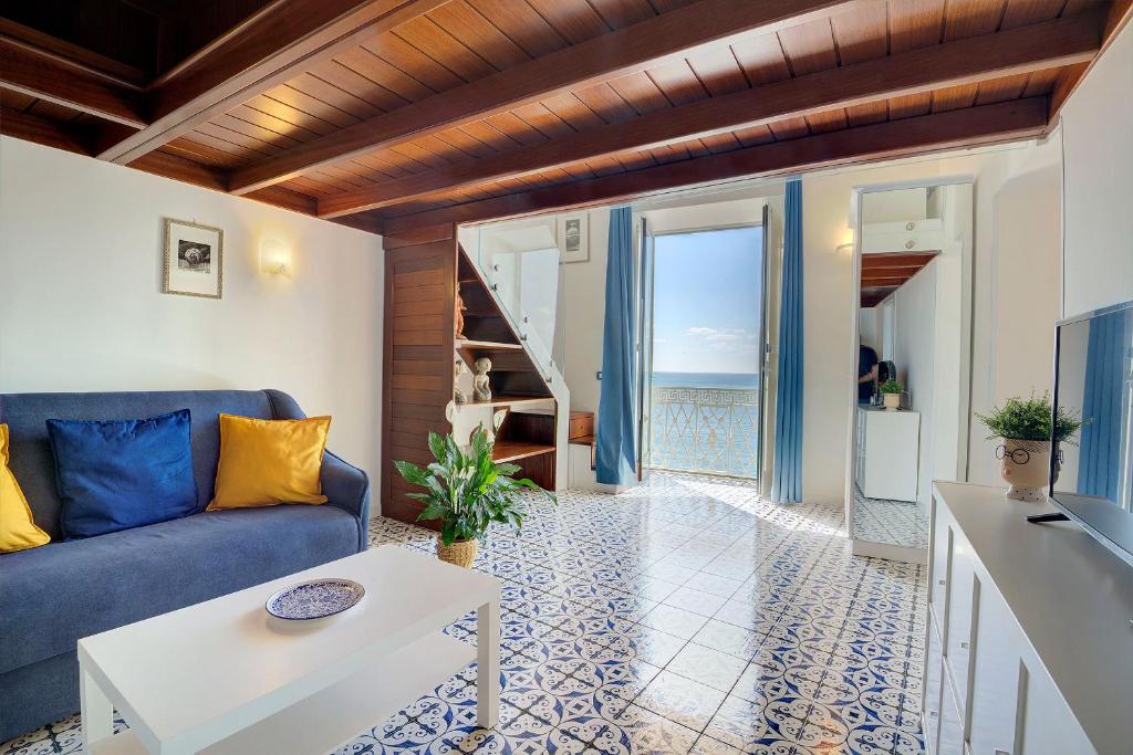 uma sala de estar com um sofá azul e uma mesa em MariLeo Amalfi em Amalfi