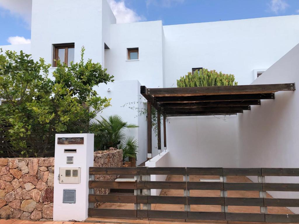 une maison blanche avec des escaliers et une clôture dans l'établissement CASA GRANADO en Cabo de Gata, à Rodalquilar