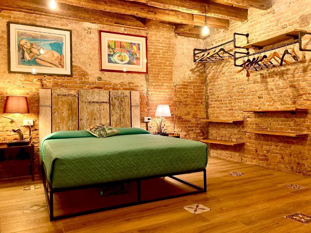 a bedroom with a bed in a brick wall at Old town Chioggia apartments in Chioggia