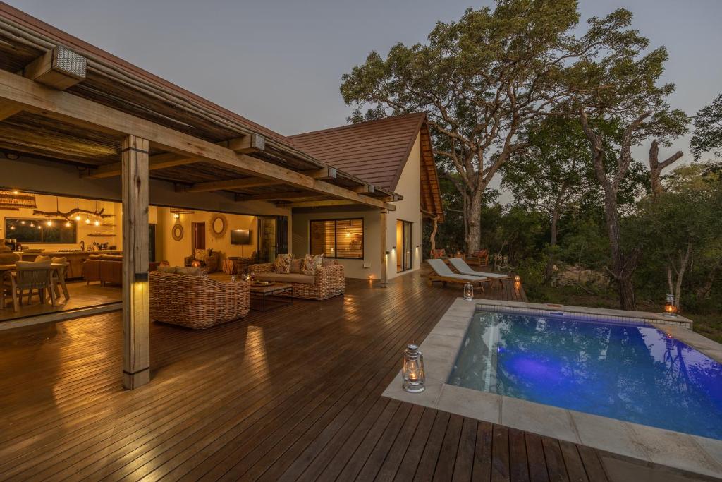une terrasse avec une piscine et une maison dans l'établissement Ukanyi Luxury Villa, à Hoedspruit