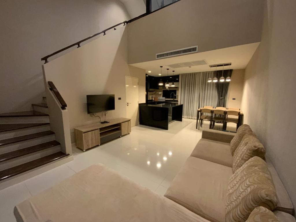 a living room with a couch and a television at Townhouse near Donmuang airport 4 bedrooms in Bangkok