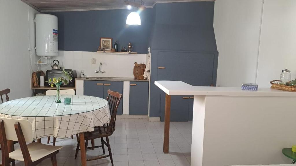eine Küche mit einem Tisch und Stühlen sowie einer blauen Wand in der Unterkunft Monoambiente pequeño in Carmen de Patagones