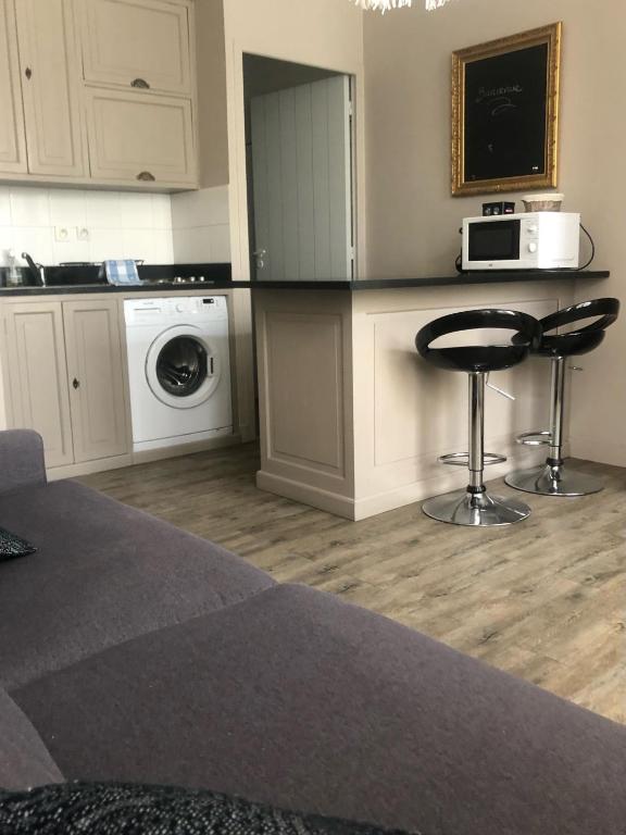 une cuisine avec un comptoir, un four micro-ondes et un tabouret dans l'établissement Au cœur historique de La Rochelle, à La Rochelle