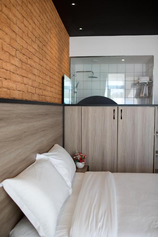 a bedroom with a bed with white pillows at ONOMO Hotel Tanger Med in Tangier