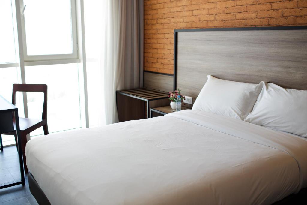 a bedroom with a large white bed and a chair at ONOMO Hotel Tanger Med in Tangier