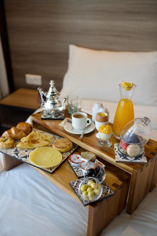 a breakfast tray with breakfast foods on a bed at ONOMO Hotel Tanger Med in Tangier