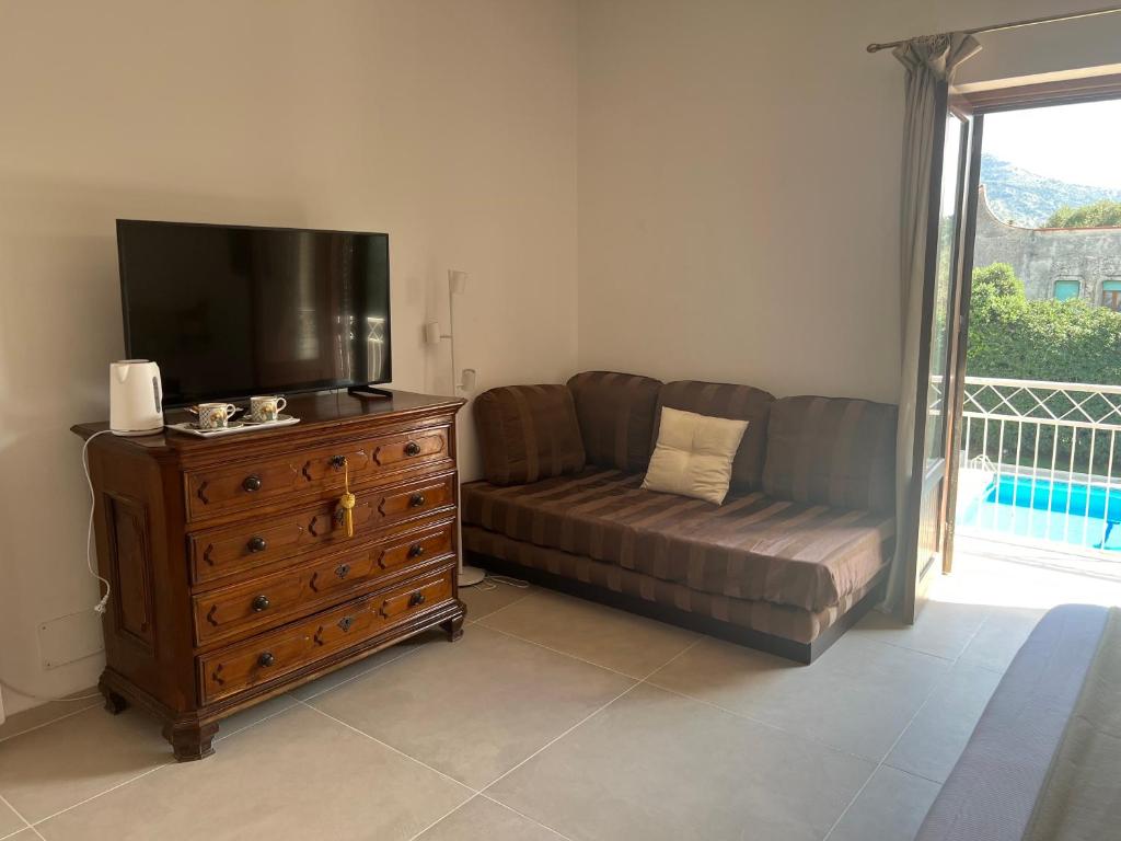 a living room with a couch and a tv and a dresser at Domus Orestea Luxury Suites in Palermo