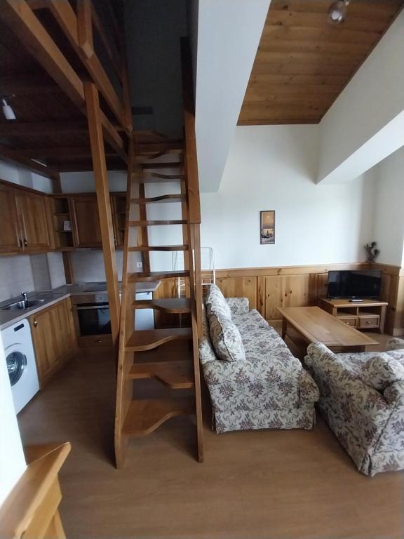 a living room with a couch and a spiral staircase at Piringolf apartment in Razlog