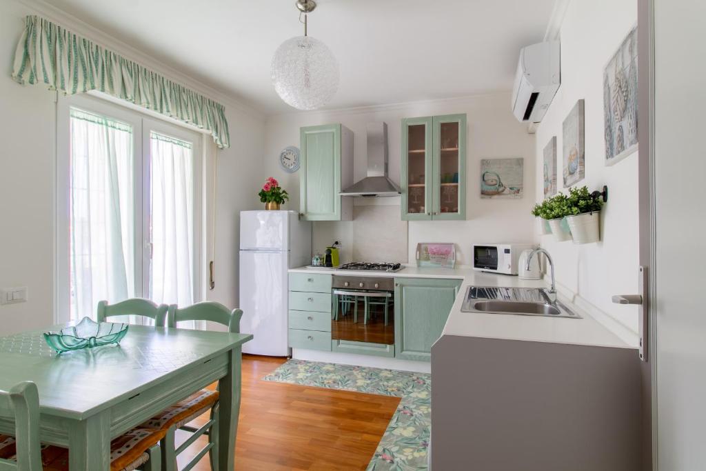 トルヴァイアニカにあるAttico Centralissimo Vista Mareのキッチン(緑のキャビネット、白い冷蔵庫付)