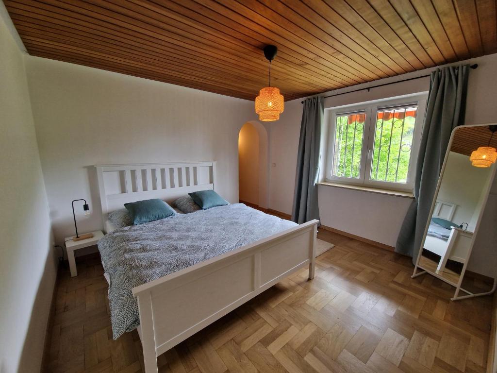 a bedroom with a white bed and a window at Ferienhaus Heinz in Heiligkreuzsteinach