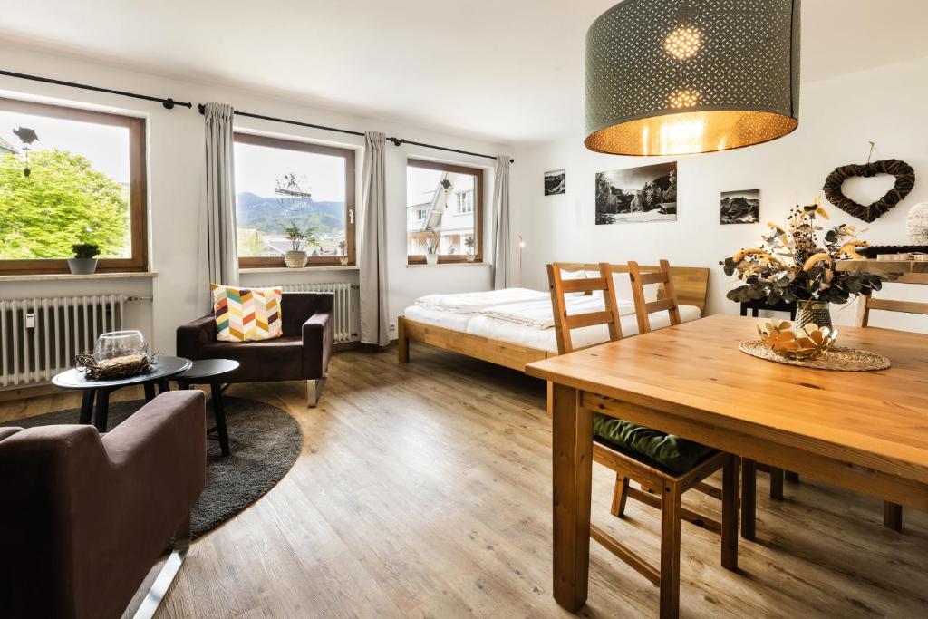 ein Wohnzimmer mit einem Tisch und ein Schlafzimmer in der Unterkunft Ferienapartment Marktblick in Oberstdorf