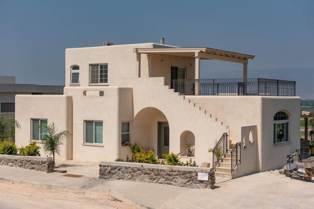 a large white house with a spiral staircase at בקצה הנוף in Kefar Szold