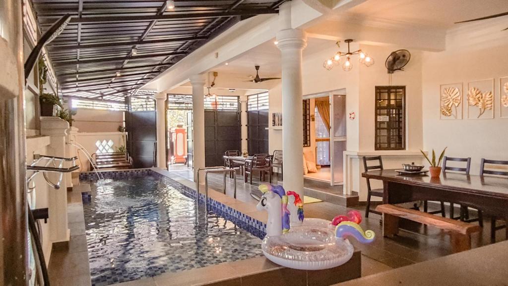 a house with a swimming pool with a rubber duck in the middle at 5BR IndoorPrivate Pool Villa BathTub BBQ Steamboat in Melaka