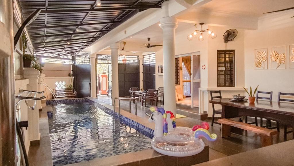 a house with a swimming pool with a rubber duck in the middle at Pool Villa Max Bath Tub BBQ Steamboat Party 5Bedroom 23Pax Full Airconditioned in Melaka