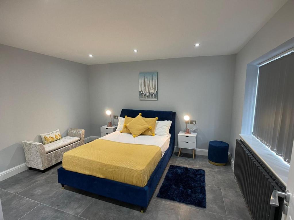 1 dormitorio con 1 cama extragrande y 1 silla en Newly refurbished 4 Bedroom House-Sleep 8-Free parking, en Canvey