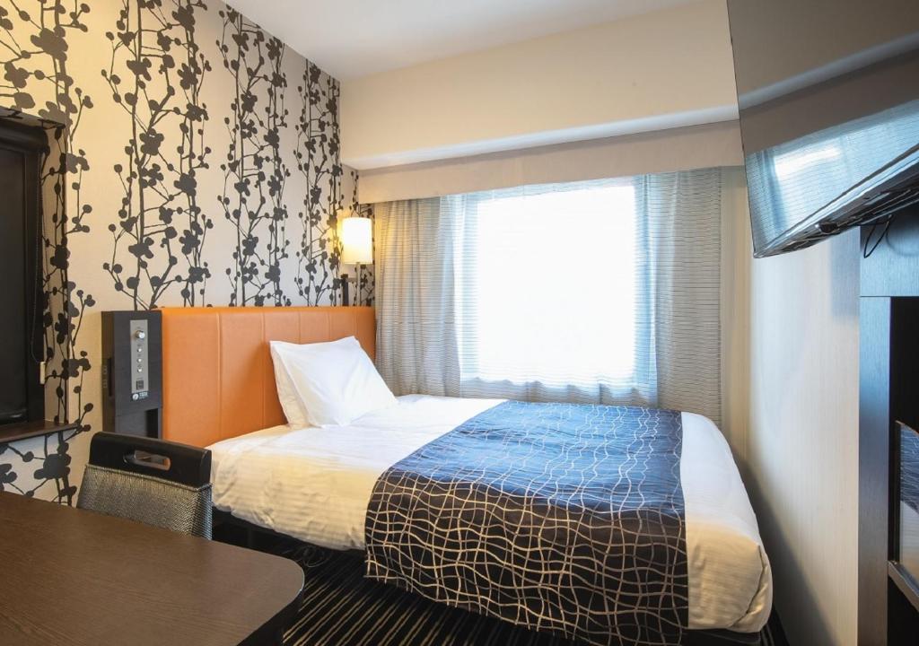 Postel nebo postele na pokoji v ubytování APA Hotel Namba Shinsaibashi