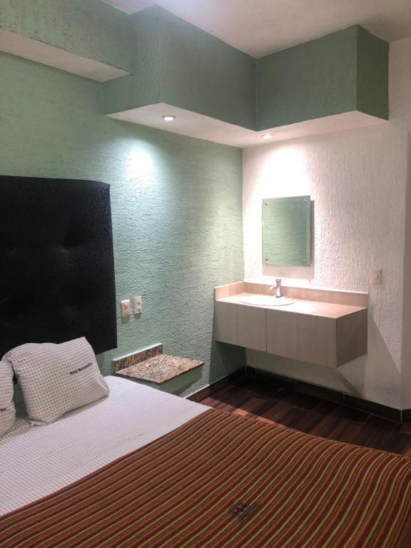 a bedroom with a bed and a sink in it at Hotel Metropolitan in Guadalajara