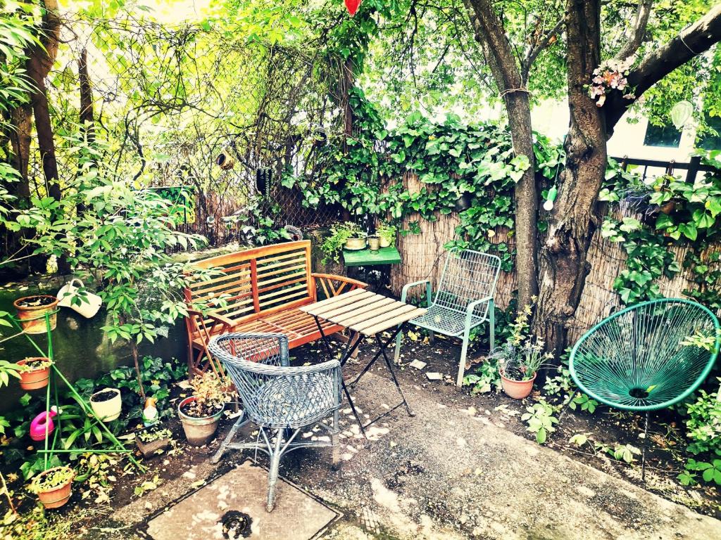 a patio with a table and chairs and plants at Flat in historic villa with your own private garden, near City Park in Budapest