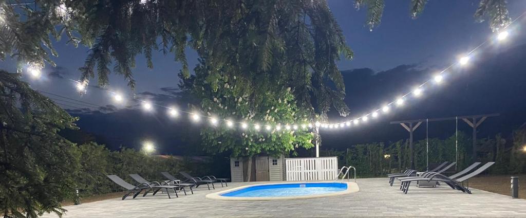 un patio con sedie e una piscina di notte di Chalet Maya a Avrig