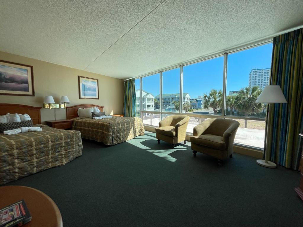 a hotel room with two beds and a large window at Oceanfront Viking Motel in Myrtle Beach