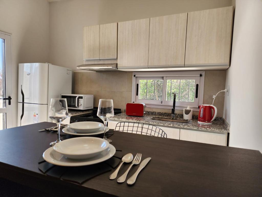 a kitchen with a black table with plates and silverware at Hunuc apartamento in Rivadavia