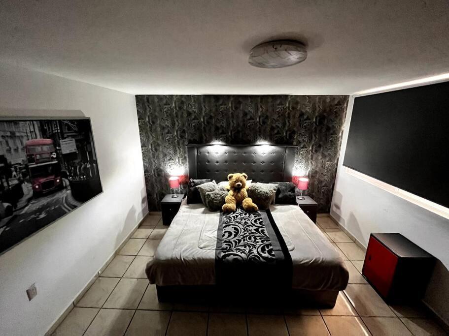 un orsacchiotto seduto su un letto in una camera da letto di Corazon de San Pedro Cholula a Cholula