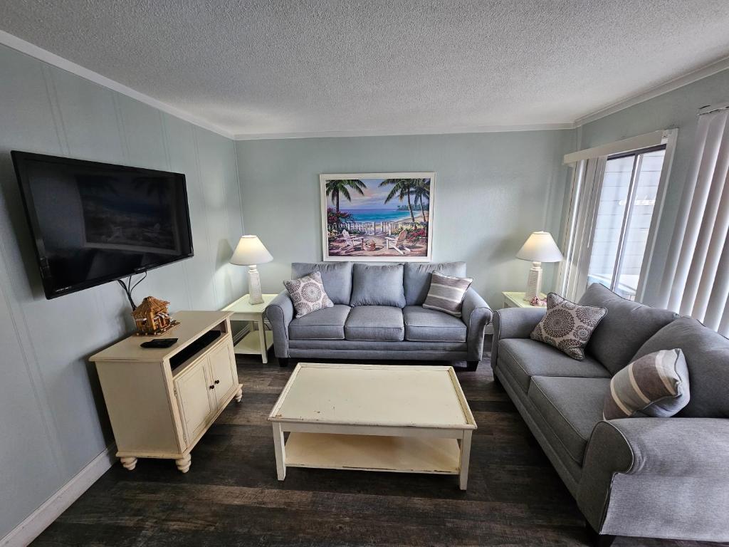 a living room with two couches and a flat screen tv at Myrtle Beach Resort- Unit A 428 in Myrtle Beach