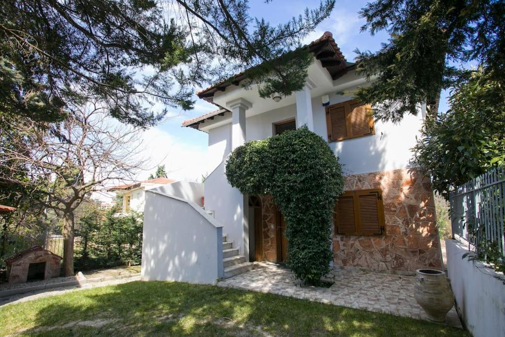 a white house with a fence and a yard at Quiet Panoramic Sea View Home in Kriopigi