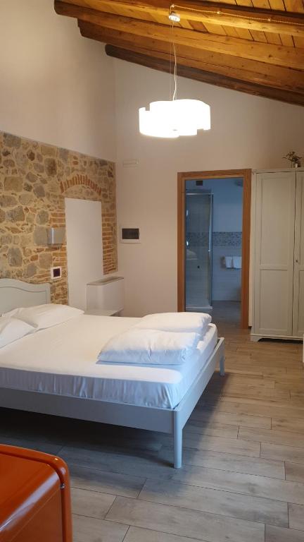 um quarto com uma cama grande e uma parede de pedra em Residenza Tito Livio Teolo em Teolo