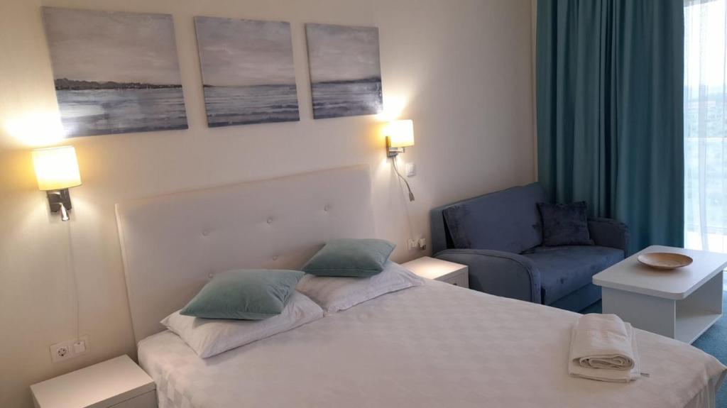 1 dormitorio con 1 cama y 1 silla azul en Studio Privat Reea Olimp, en Olimp