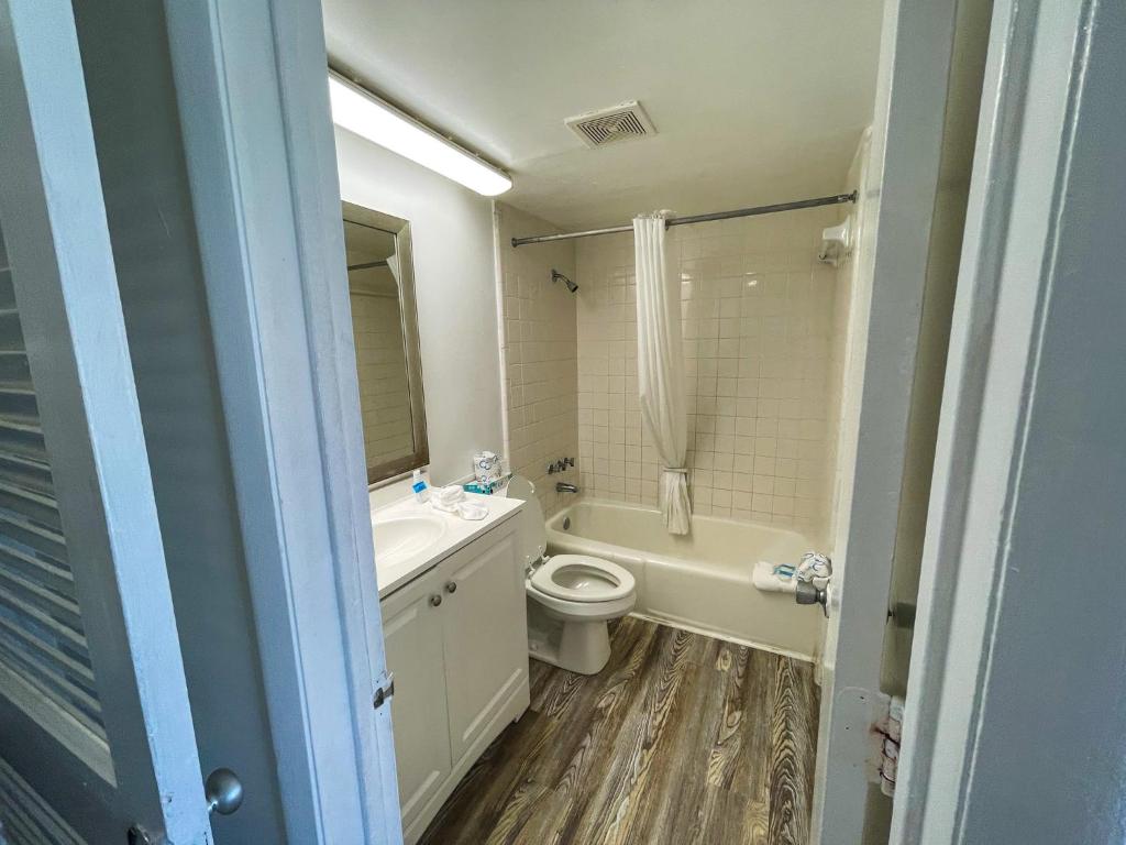 a bathroom with a toilet and a sink and a tub at Oceanfront Viking Motel in Myrtle Beach