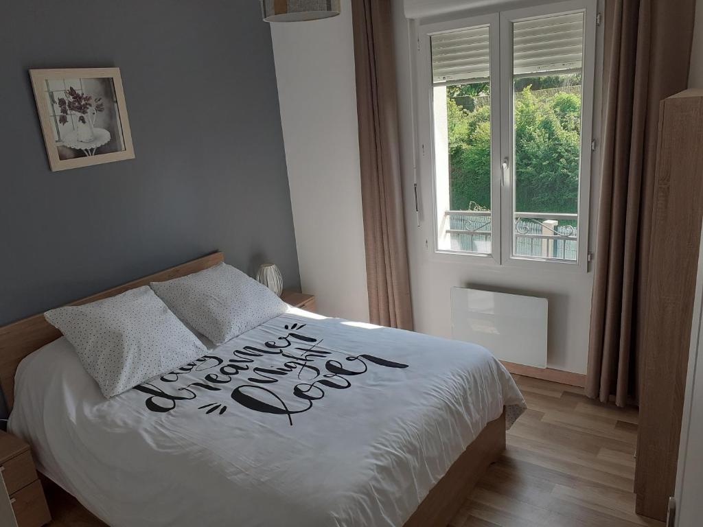 ein Schlafzimmer mit einem Bett mit einem glücklichen Neujahrszeichen darauf in der Unterkunft SAPHIR in Nogent-sur-Oise