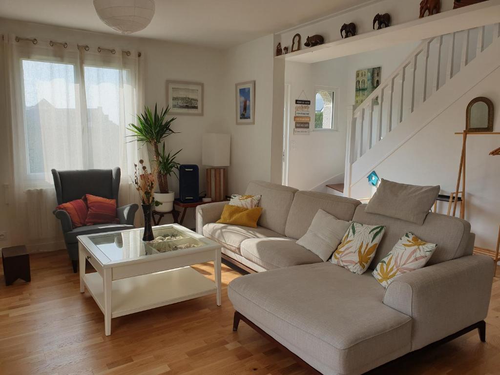 a living room with a couch and a table at Maison à Roscoff à 150 m de la thalasso et des plages in Roscoff