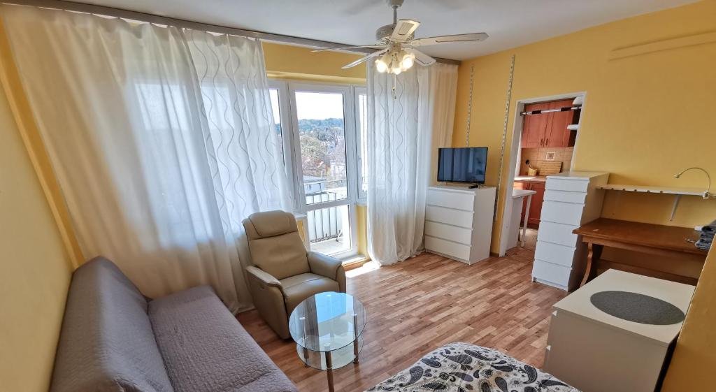 een woonkamer met een bank, een bureau en een televisie bij Mango Lu z balkonem, plaża 300m in Sopot