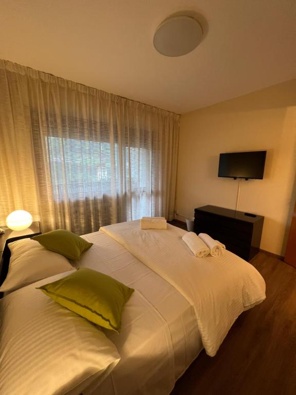 uma grande cama branca num quarto com uma janela em Belvedere da Cesarina em Tarvisio