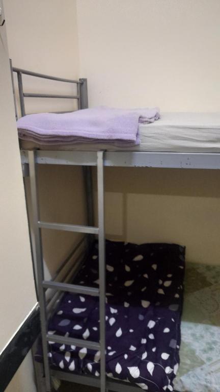 a bunk bed with a chair under a desk at Bunk bed private room Avani in Dubai
