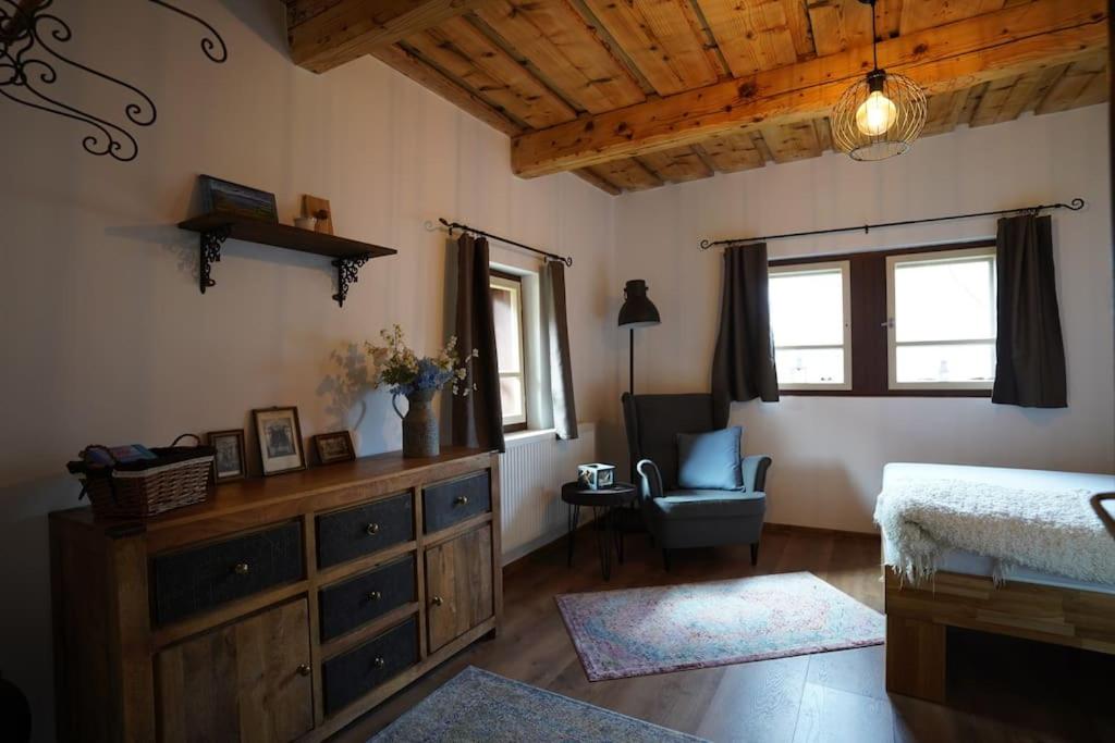 Drevenica Harmony so saunou في روجومبيروك: غرفة نوم مع خزانة وكرسي في الغرفة
