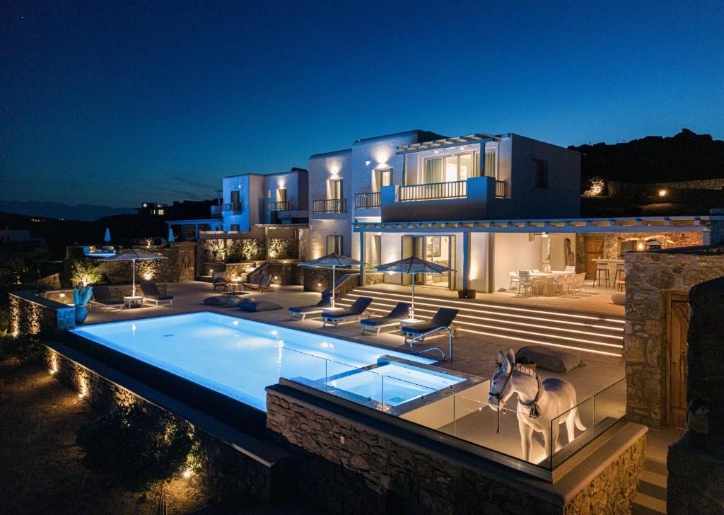 a house with a swimming pool at night at Ethereal Villa Mykonos in Kalafatis