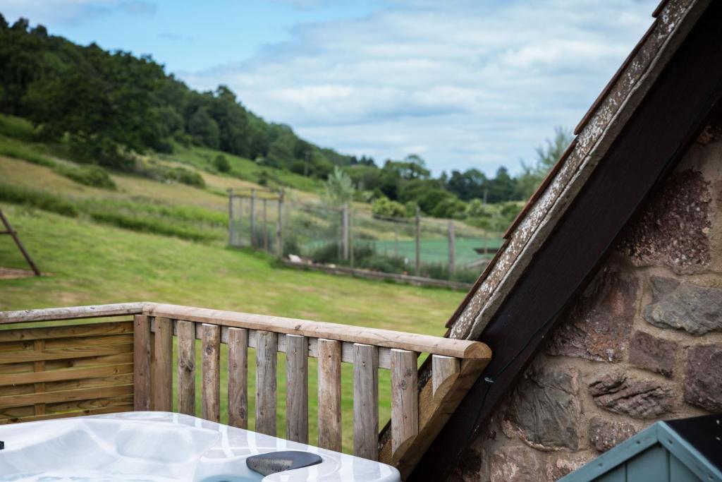 uma varanda com uma mesa e vista para um campo em Brambles em Little Dean