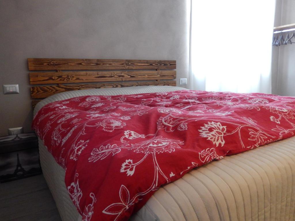 Una cama con colcha roja y blanca. en Affittacamere Happy, en Porto SantʼElpidio