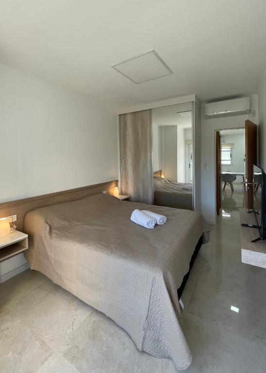 - une chambre avec un grand lit et un miroir dans l'établissement Regia Apartamentos Villa Sarita, à Posadas