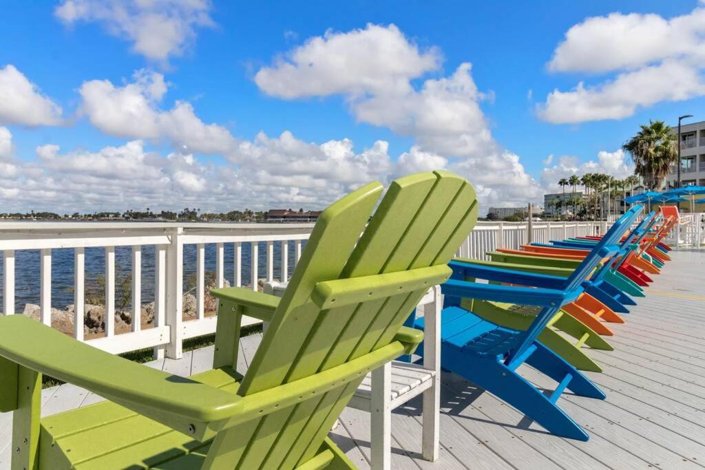 a row of lawn chairs sitting on a boardwalk at Beachy Daze-Waterfront - WIFI - Heated Pool in Tampa